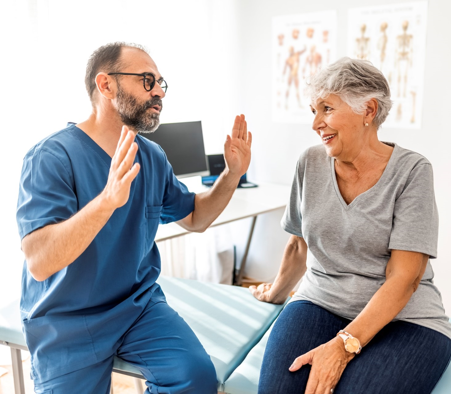 4bedff08afba22bb3391a6a26941f4087abb4ac8 Cropped shot of a handsome mature male physiotherapist doing a consultation and assessment with a senior female patient.